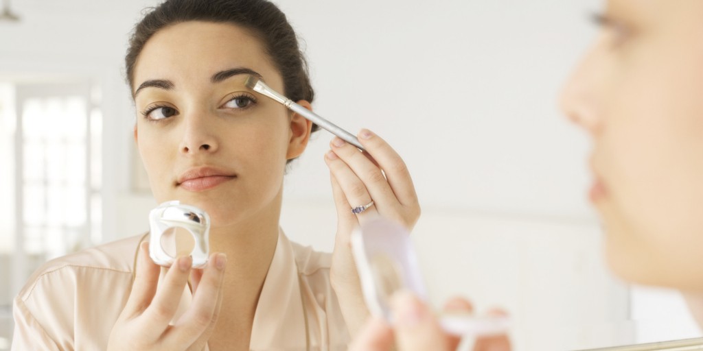 Young woman applying make-up