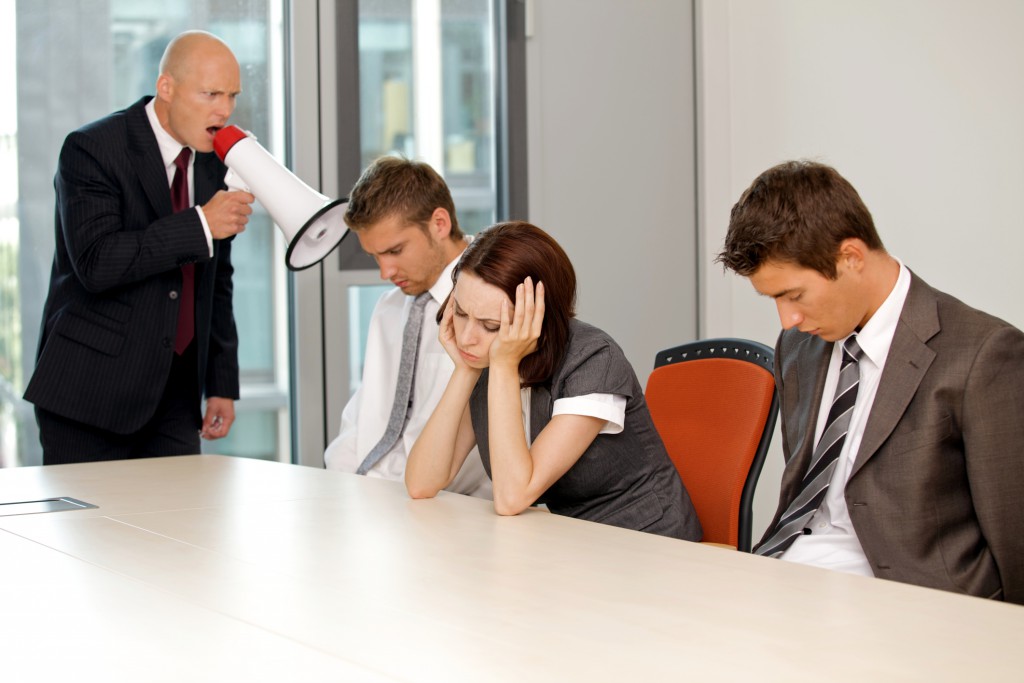 Young confident caucasian businessman screaming on his employee