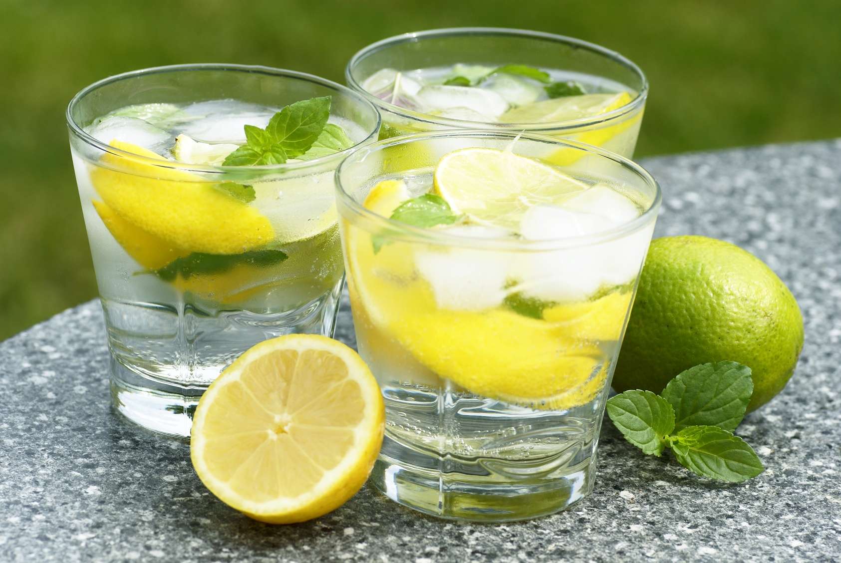 Fresh summer drink with ice cubes, lemon, lime and mint.